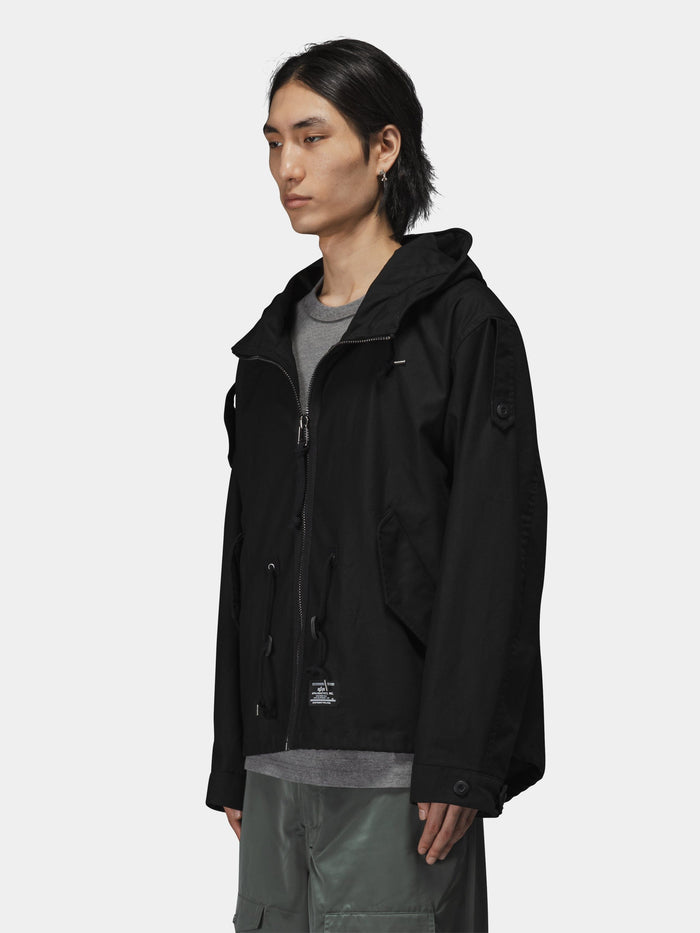 Alpha Industries M-65 Mod Fishtail Field Coat in black with fishtail hem, worn over gray shirt and green pants.