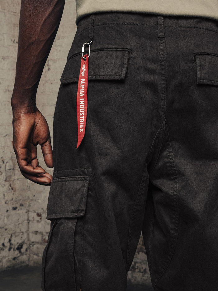 Alpha Industries Acu Pant black cargo pants with utility pockets and red Alpha Industries keychain on a pocket.