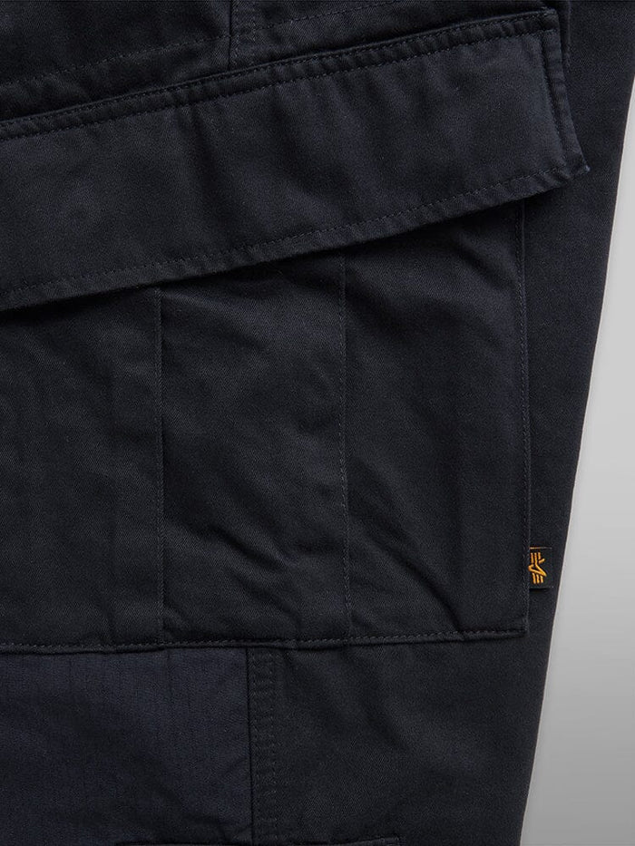 Acu Pant cargo pocket by Alpha Industries with black flap, small orange tag, and utility pockets.