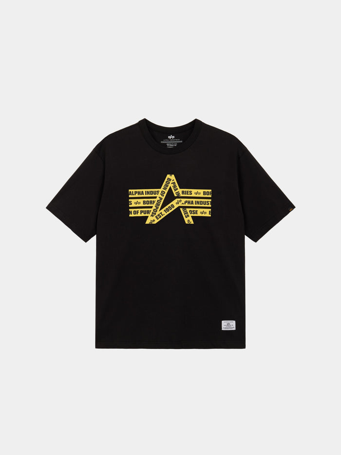 Alpha Caution Tape Tee by Alpha Industries is a black short-sleeve shirt with yellow graphic and diagonal Alpha Industries text on front.