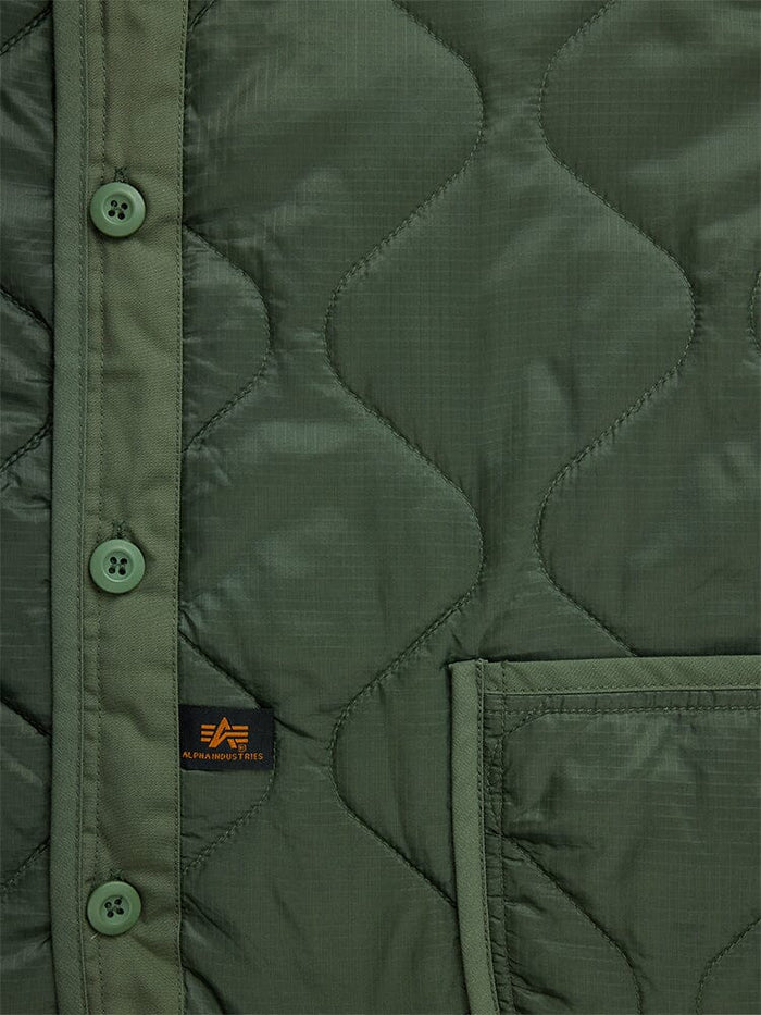 Alpha Industries Als/92 Liner in olive green with quilted design, buttons, pocket, and small brand tag.