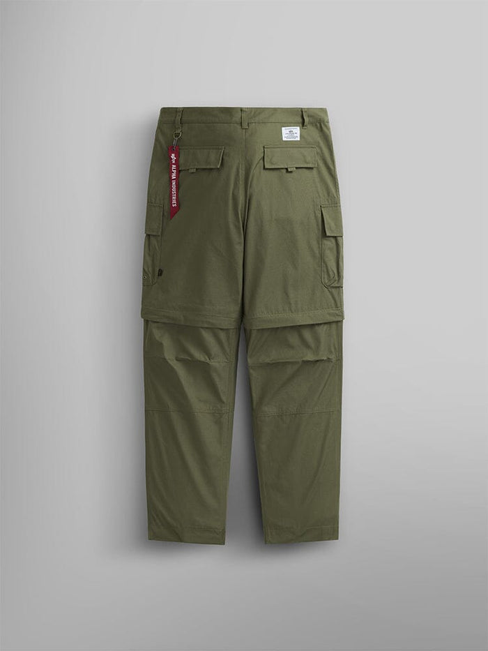 Alpha Industries Convertible Cargo Pant in OG-107 green with flap pockets, white label above right pocket, and red keychain on belt loop.
