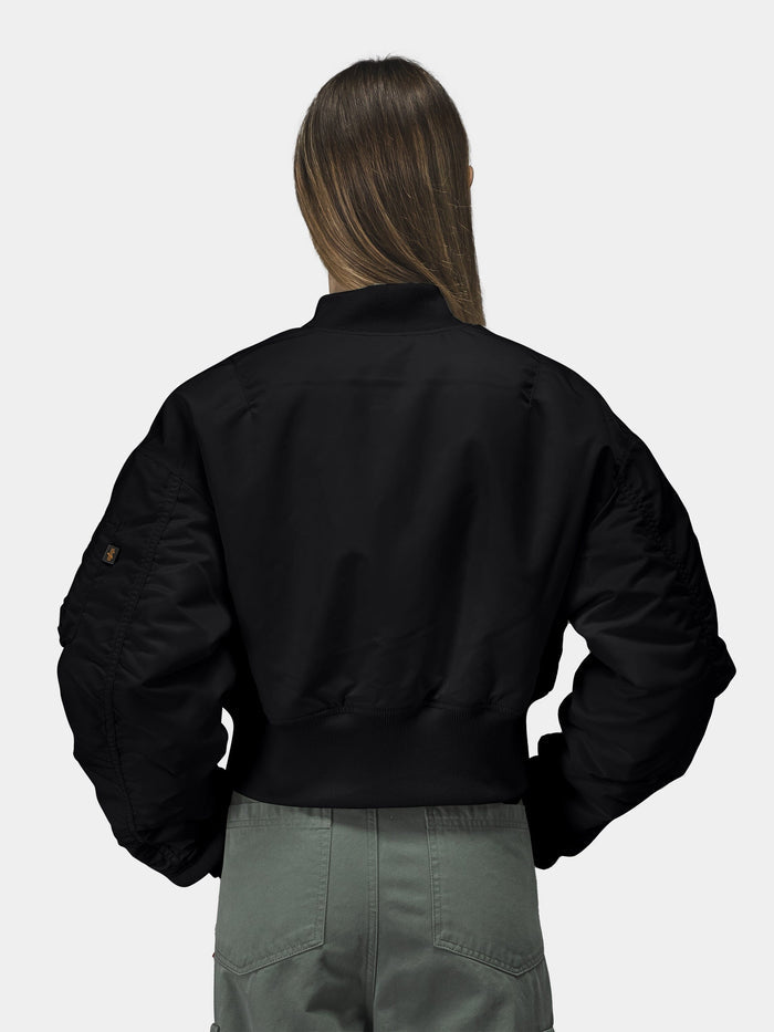 Alpha Industries Cropped MA-1 Flight Jacket Womens in black, paired with olive green pants.