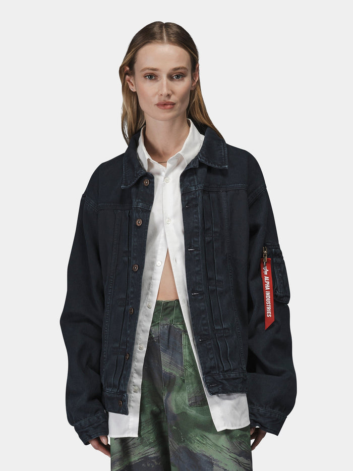 Alpha Industries Ctn Work Overshirt in dark cotton, layered over white button-up shirt and green patterned pants.