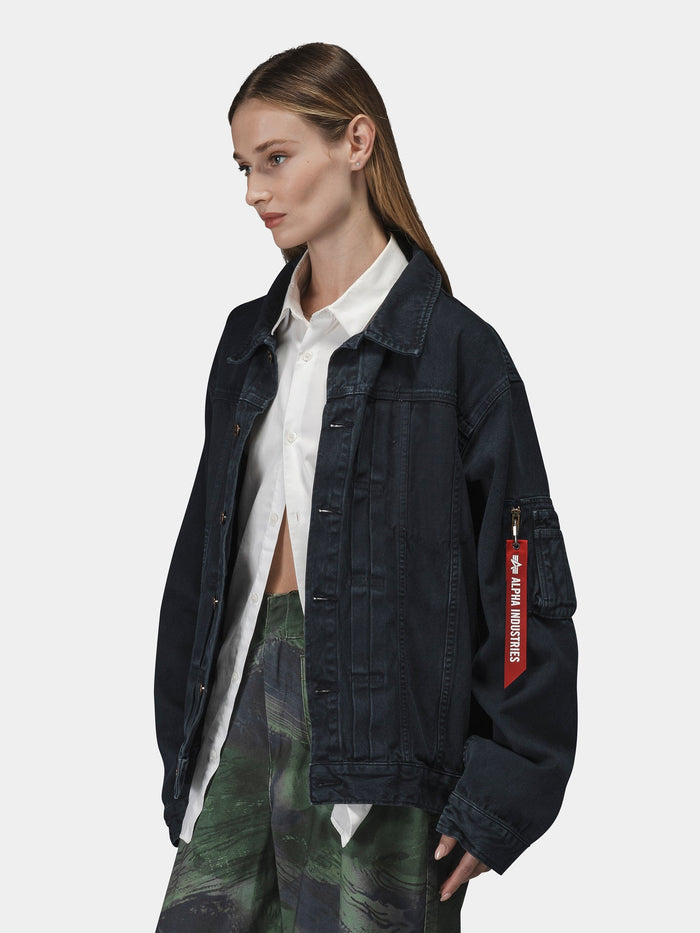 Alpha Industries Ctn Work Overshirt in dark denim with a red Remove Before Flight tag, white shirt, and patterned green pants.