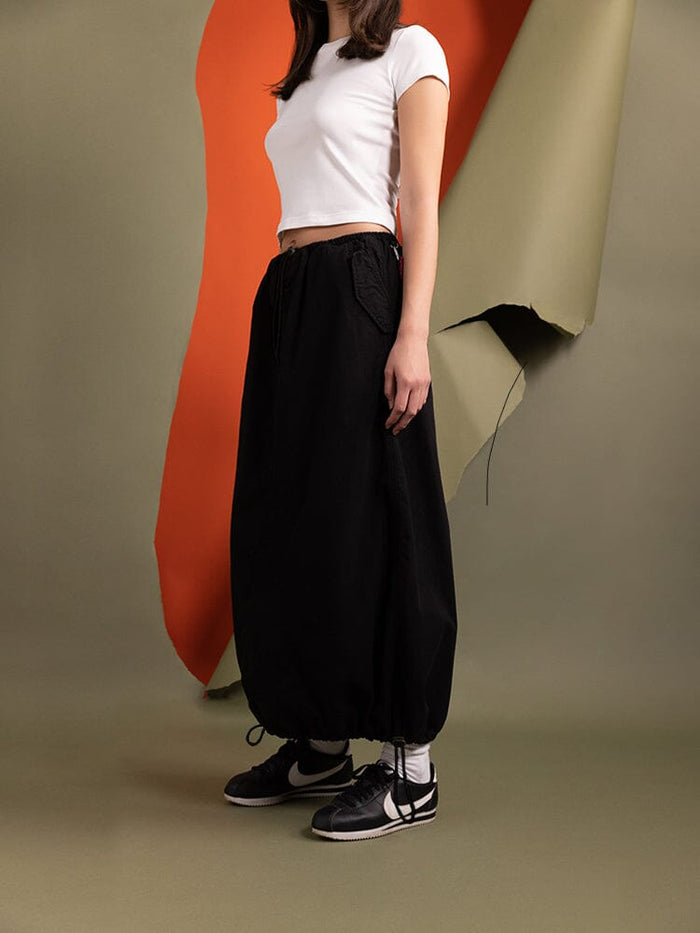 Side view of a person wearing the Women's Drawcord Skirt in black by Alpha Industries.