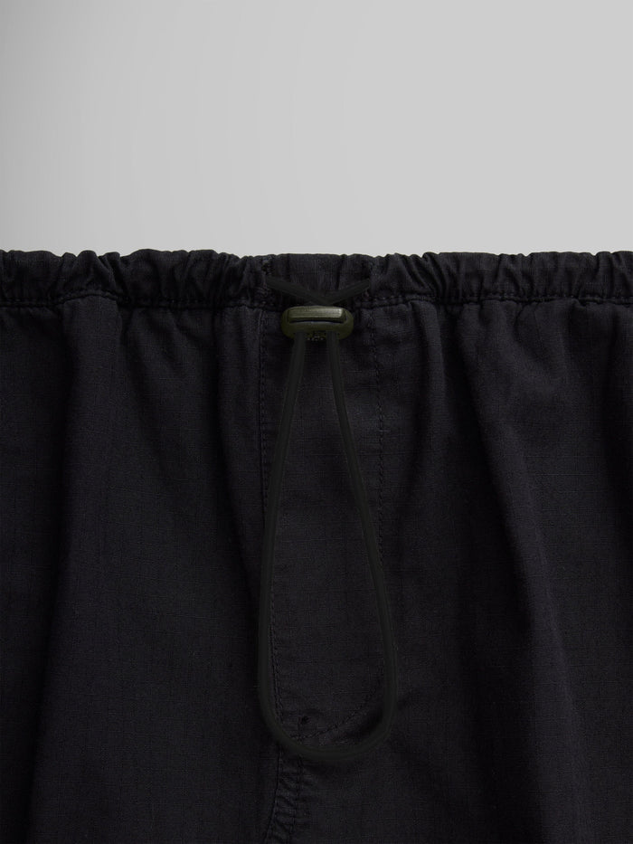 Close-up of the Women's Drawcord Skirt by Alpha Industries, showcasing its black fabric with a bungee waistband and drawstring tied in a loop.