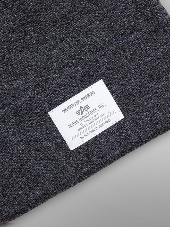 Essential Beanie by Alpha Industries in dark gray with a white brand label stitched on the cuff.