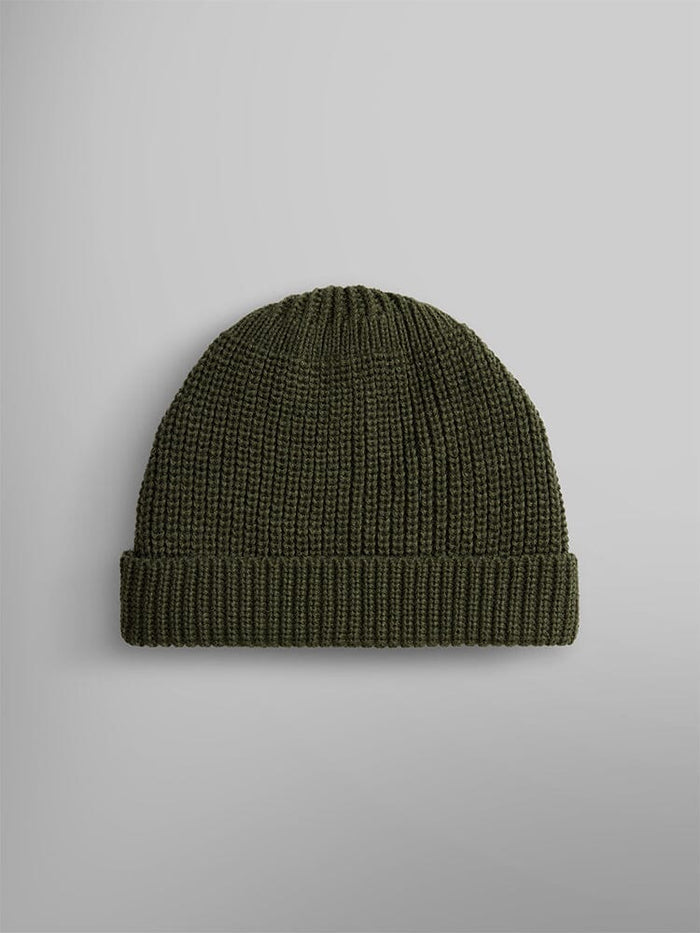 The Essential Watch Cap from Alpha Industries is a dark olive green wool-blend knitted beanie hat, evoking the timeless style of classic watch caps.