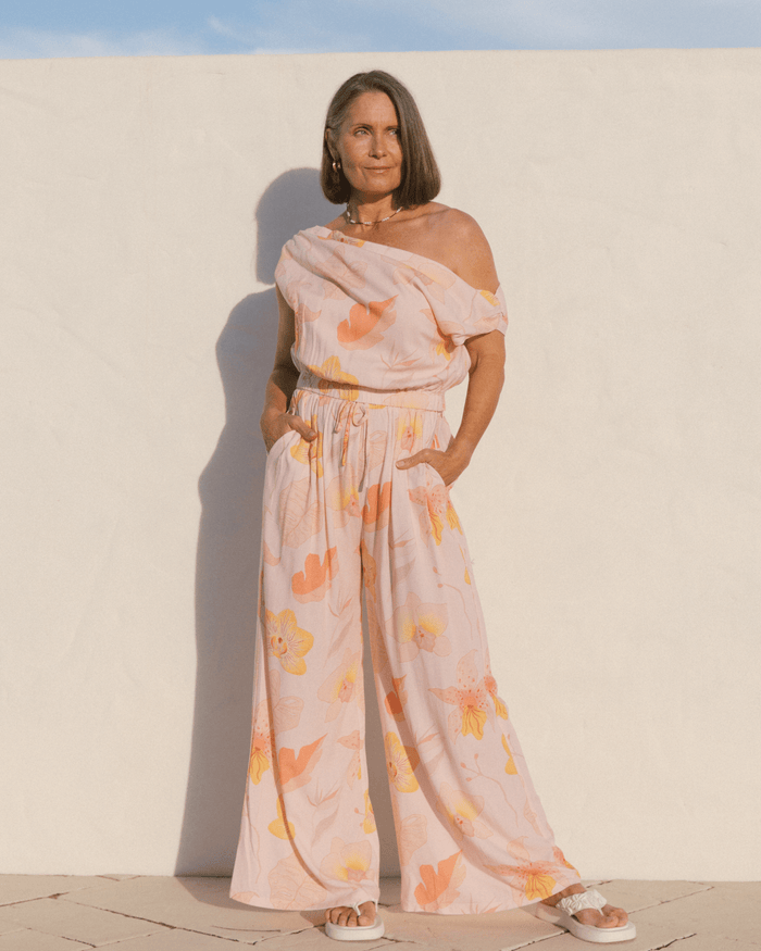 Woman wearing a stylish spring outfit in a light pink floral design.