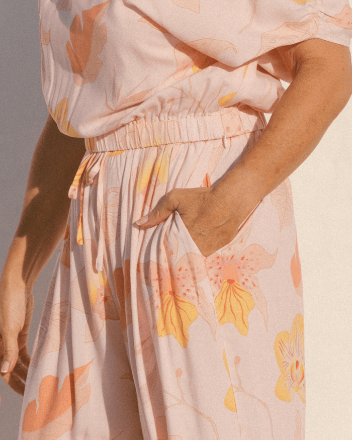 Close-up of elastic waistband of crop top & pocket of wide legged lounge pants.