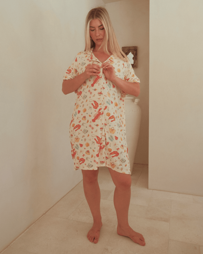 Woman wearing a breathable, button-down nightie, featuring a Australian Christmas pattern.