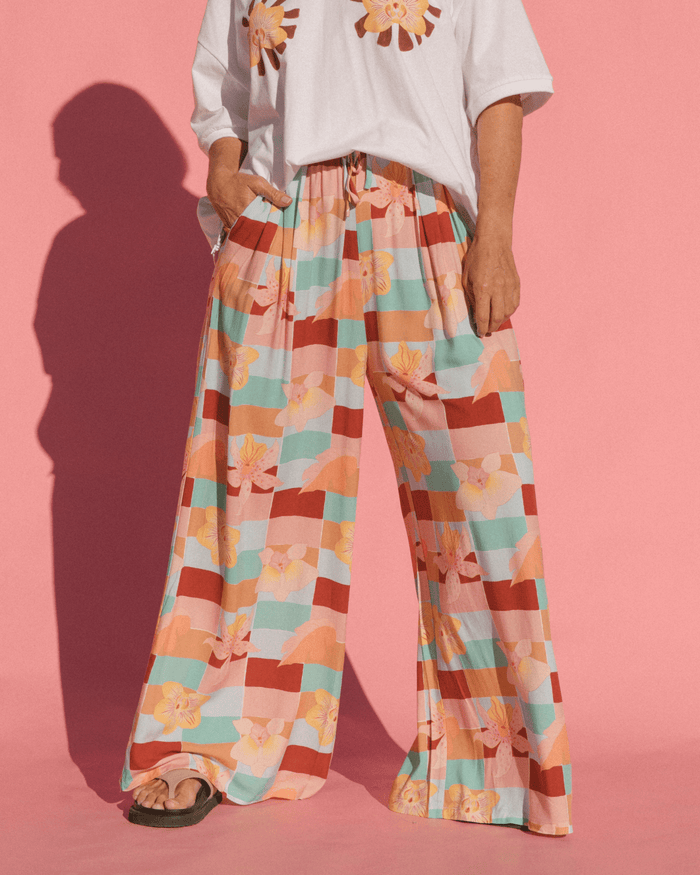 Woman wearing flowy wide legged maternity pants with elastic adjustable waistband.
