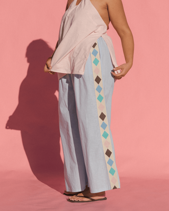 Women wearing breastfeeding friendly fashion halter top and showing the side-seam zippers for feeding access.