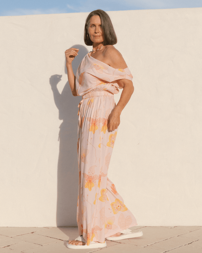 Woman wearing a spring co-ord set with an off the shoulder crop top and high-waisted flowy pants.