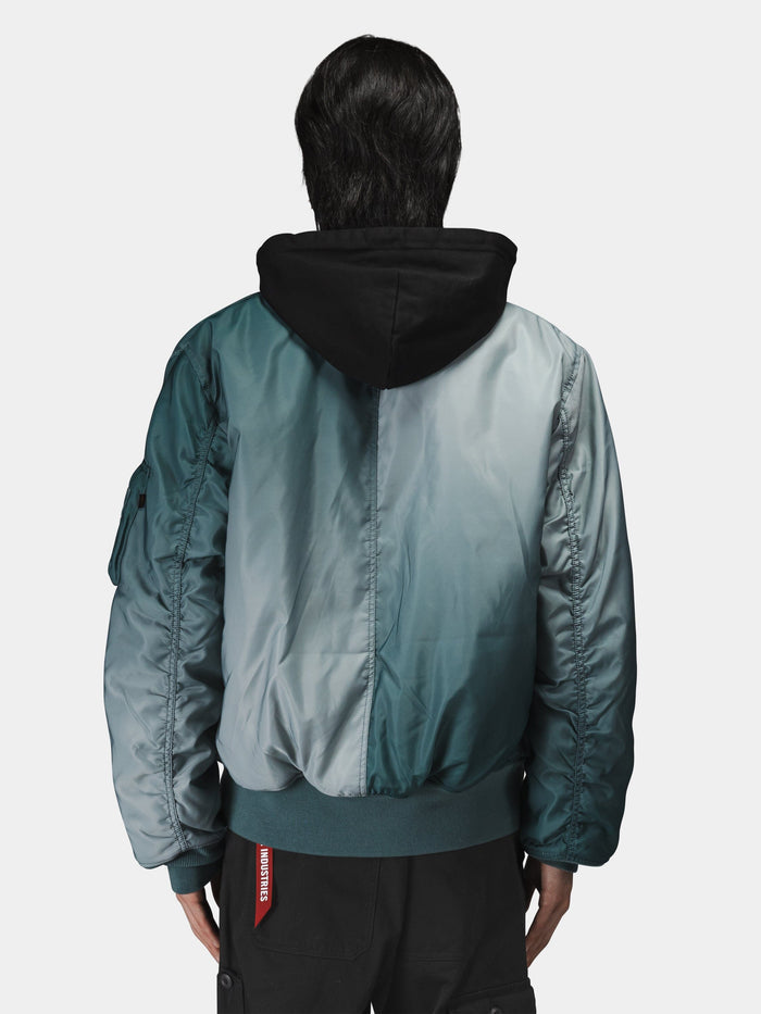 Alpha Industries Gradient Washed Flight Jacket in teal with black hood and visible red tag on the side.