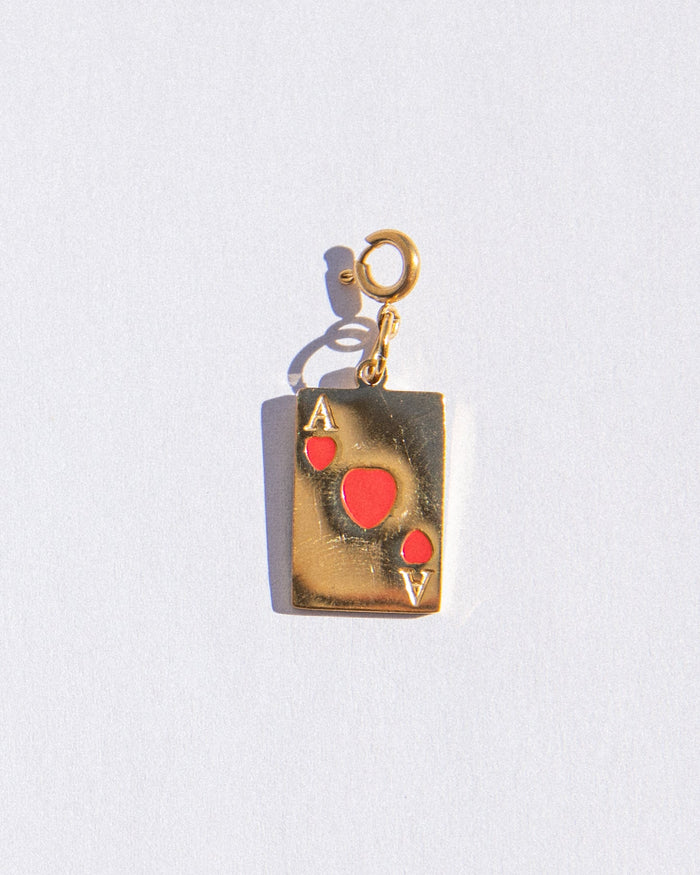 Gold pendant shaped like an Ace of Hearts card on a white background