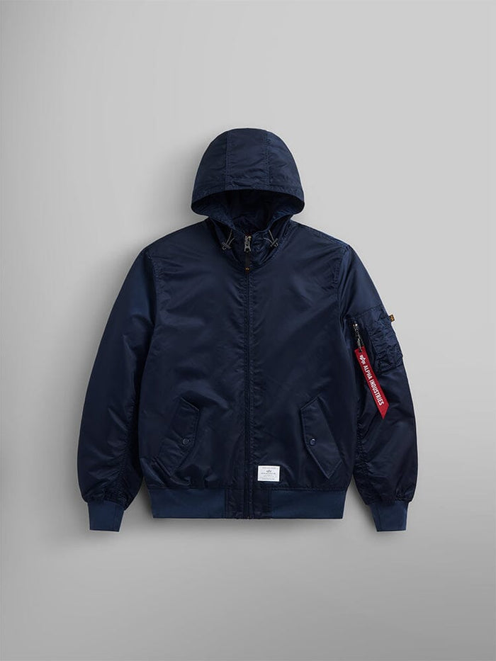Introducing the Alpha Industries, Inc. L-2B Hooded Gen II Bomber Jacket in Replica Blue. This jacket is expertly crafted from water-resistant nylon and features a front zipper, two front pockets, and a distinctive red tag on the sleeve.