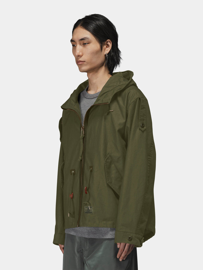 Alpha Industries M-65 Mod Fishtail Field Coat in olive green with fishtail hem, worn over gray shirt.