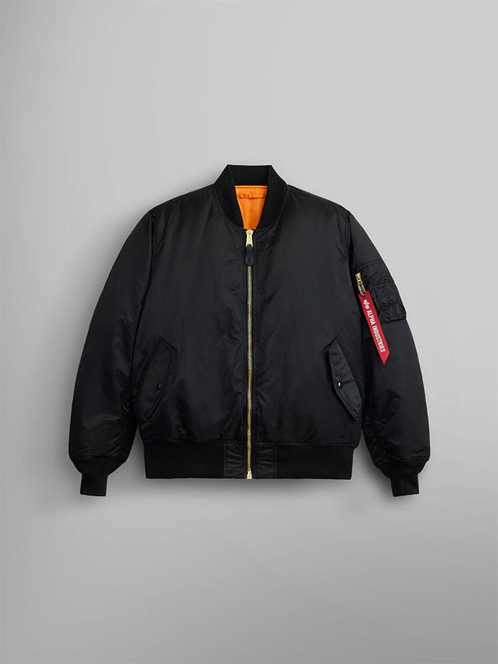 Alpha Industries MA-1 Bomber Jacket in black with gold zipper, orange lining, ribbed cuffs and hem, red tag on left sleeve pocket.