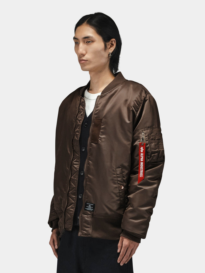 Alpha Industries MA-1 Mod Bomber Jacket in brown with red Remove Before Flight tag and sleeve utility pocket.
