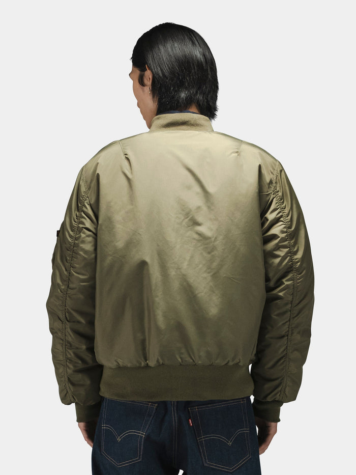 Alpha Industries MA-1 Oxford Flight Jacket in olive green with blue jeans.