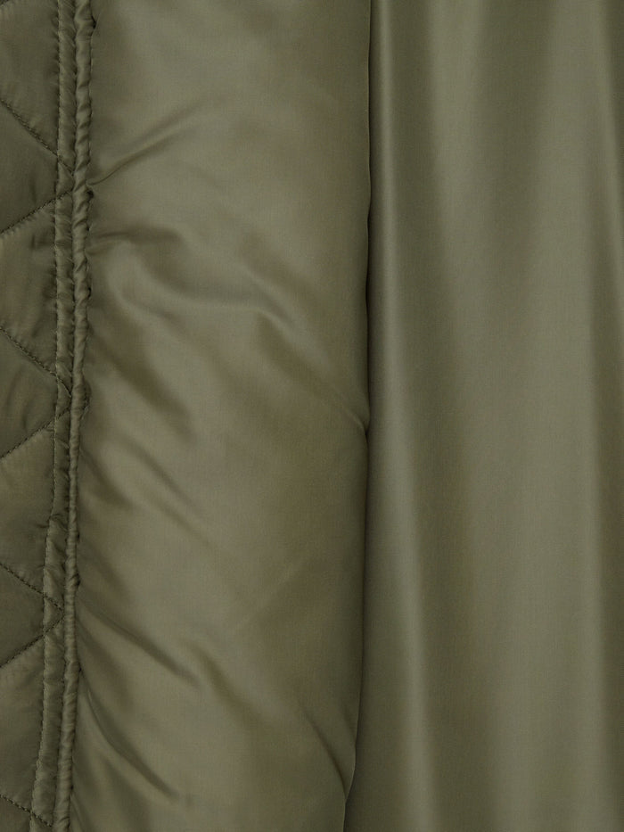 Olive green quilted fabric and smooth, slightly shiny surface of the Alpha Industries MA-1 Oxford Flight Jacket.