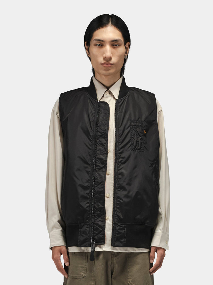 Alpha Industries MA-1 Oxford Vest in black, beige button-up shirt, khaki pants.