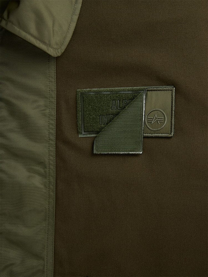 Alpha Industries Mixed Media CWU 36P Mod Jacket, olive green patch with Velcro flap, partially open to show brand name and logo.