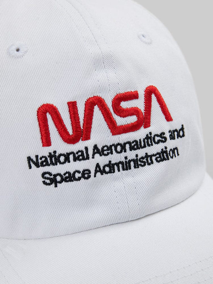 Close-up of the NASAa Worm Logo Cap by Alpha Industries. This white cap showcases the NASA worm logo, with "National Aeronautics and Space Administration" embroidered in red and black.