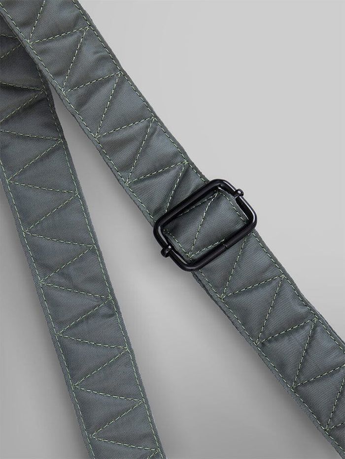 Close-up of the durable nylon strap from the Alpha Industries Nylon Messenger Bag, featuring an adjustable black buckle and visible stitching.