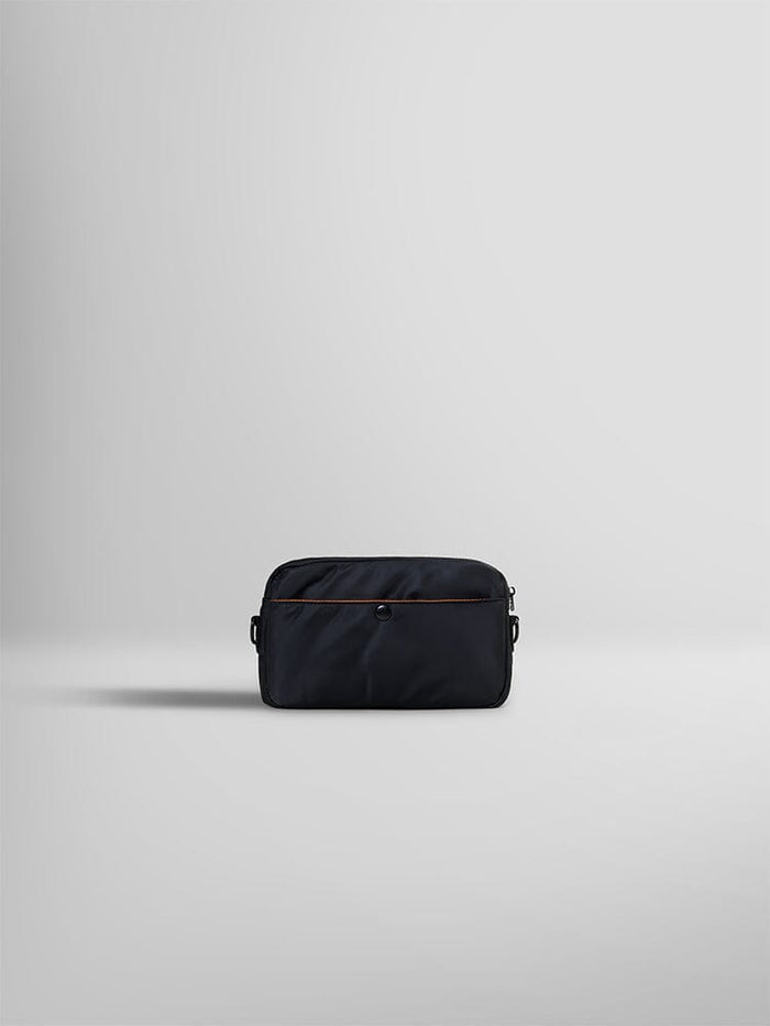 The Nylon Messenger Bag by Alpha Industries is elegantly displayed. This black fabric pouch is crafted from durable nylon and features a brown zipper with side loops.