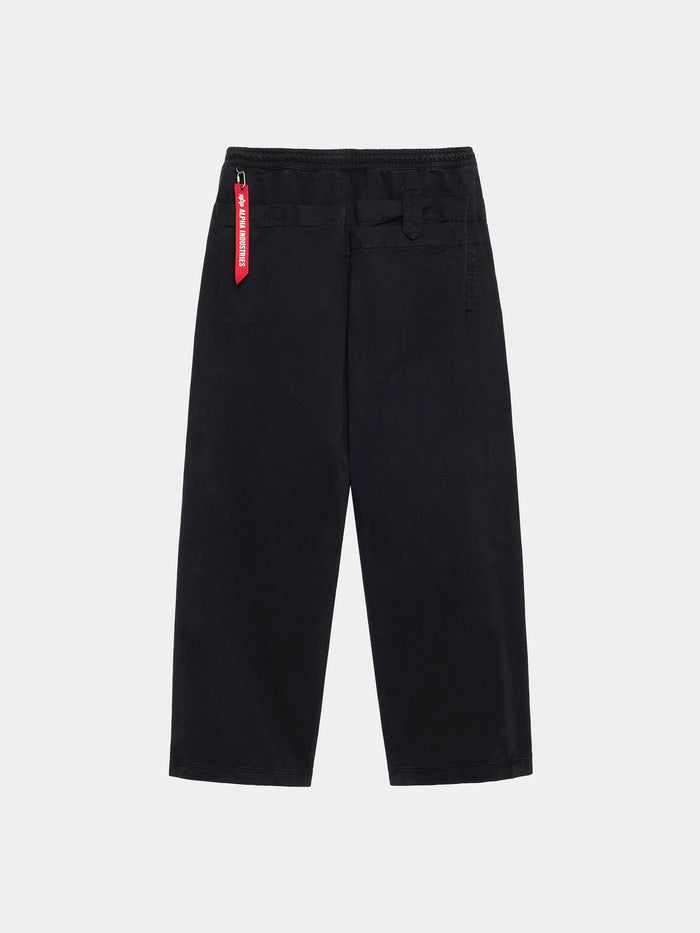The Alpha Industries Oversized Washed Pant in black, 100% cotton, with a red tag.