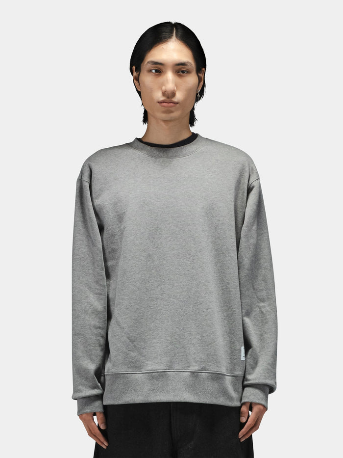 Alpha Industries Patched Crewneck sweatshirt in black with military-inspired patches, paired with black pants.