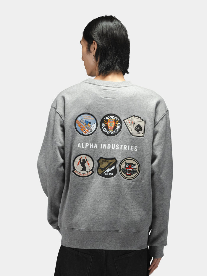 Patched Crewneck by Alpha Industries, cotton-poly sweatshirt with colorful patches and Alpha Industries branding on back.