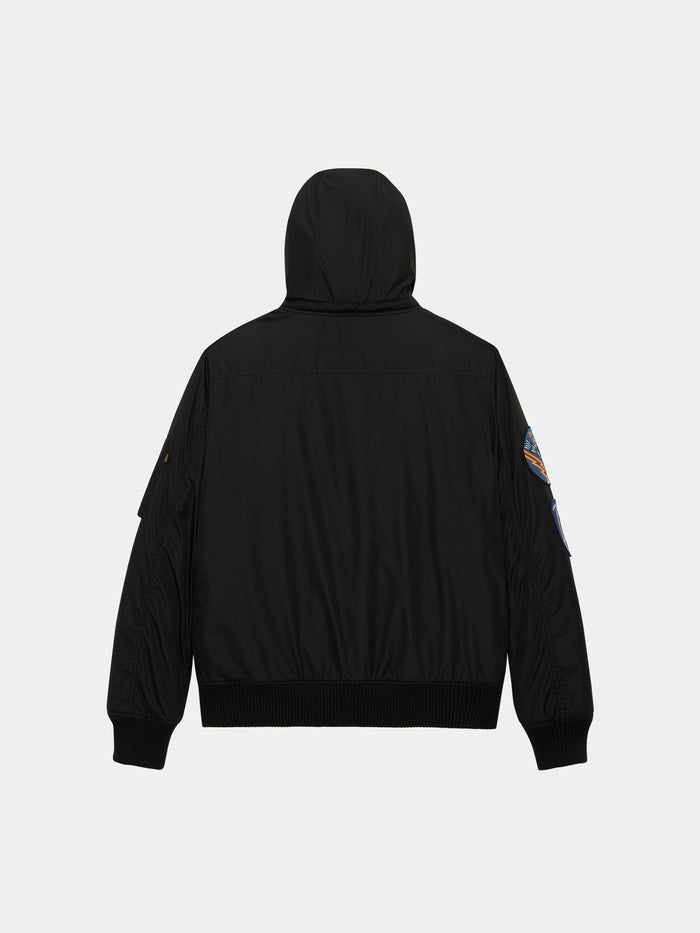 Patched Hooded Rib Flight Jacket by Alpha Industries in black with ribbed cuffs, waistband, and patch on left sleeve.