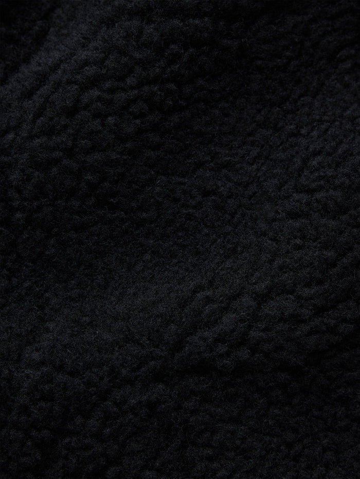 Alpha Industries Sherpa Onion Quilting Flight Jacket, black textured fleece fabric with irregular patterns.