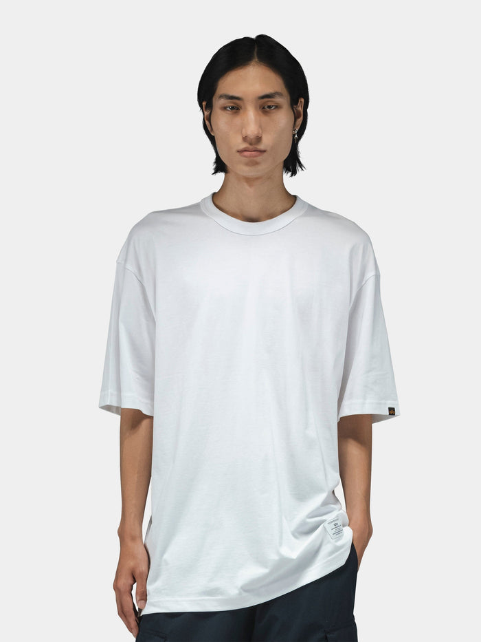 Alpha Industries Short Sleeve Relaxed Tee in dark color, paired with dark pants.
