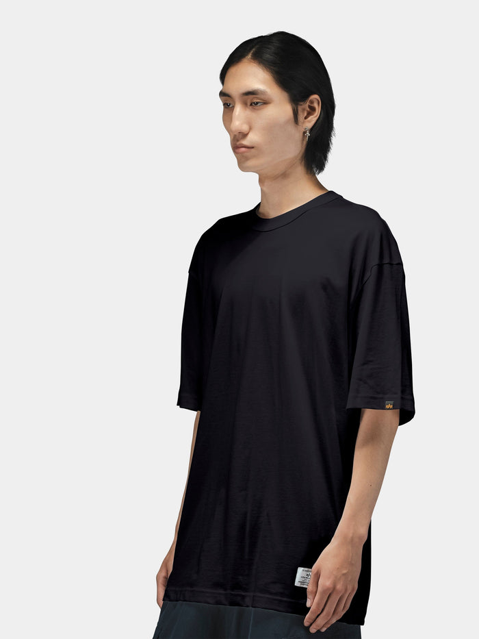Alpha Industries Short Sleeve Relaxed Tee in black, paired with dark pants.