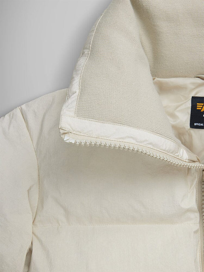 Close-up of the Sierra Short Puffer W in cream with a half-zipped collar, revealing the Alpha Industries label on the inside.