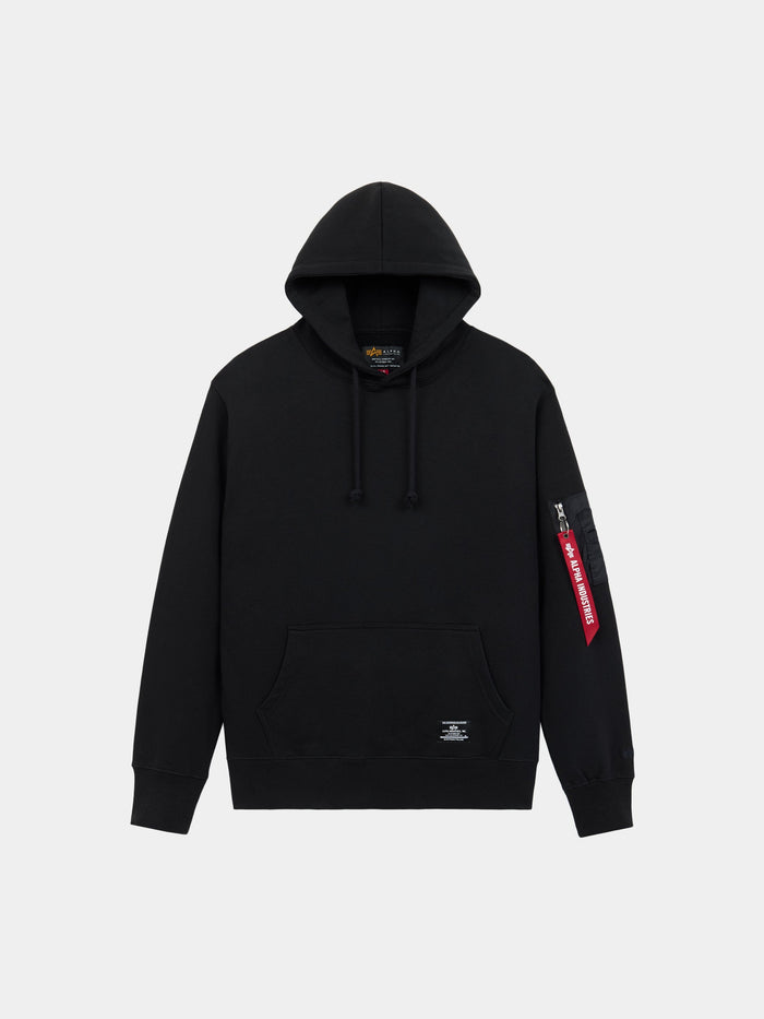 Alpha Industries Utility Pocket Hoodie in Black with front pocket and red tag on the MA-1 utility sleeve pocket.