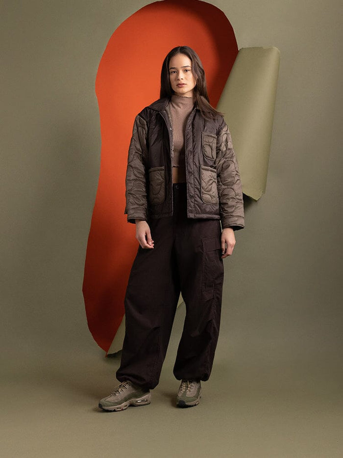 Full body view of a person wearing the Women's Insulated Chore Coat in chocolate from Alpha Industries.