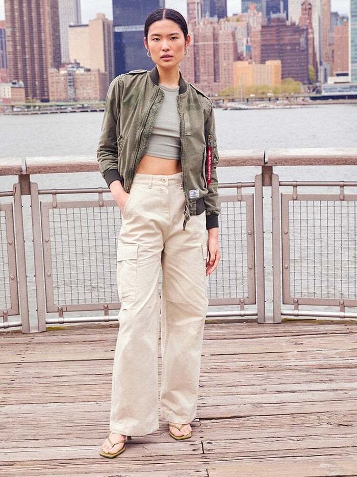 Alpha Industries Womens M-65 Cargo Pant in Limestone, olive bomber jacket, light green crop top, flip-flops.