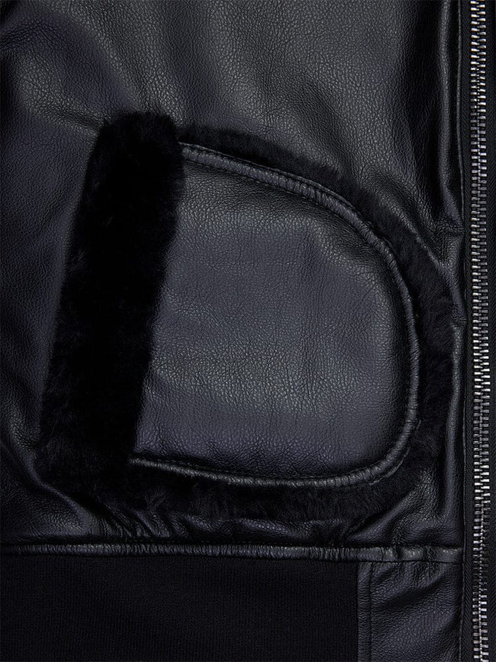 Close-up of the women's reversible faux leather MA-1 bomber jacket in black by Alpha Industries, featuring a shearling-lined pocket and prominent metal zipper.